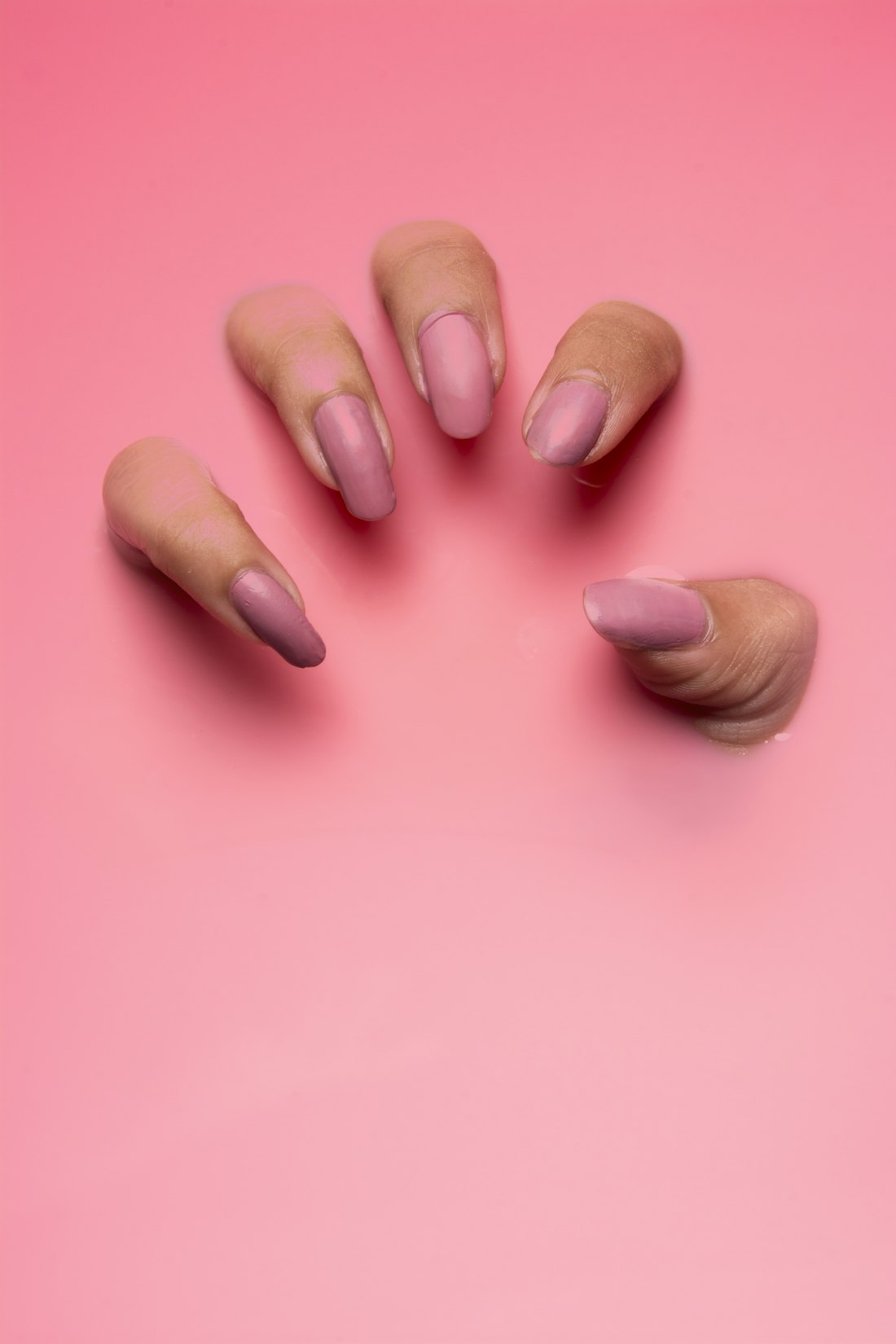 Dusty rose nails on a pink background